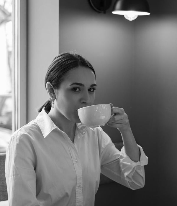 Woman stretching in a calm, modern space with warm morning light.